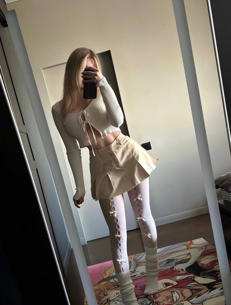 Селфи Маши у зеркала в мини юбке и белых чулках.