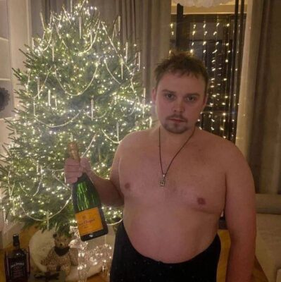 Новогоднее фото GUACAMOLEMOLLY с шампанским и голым торсом у ёлки.